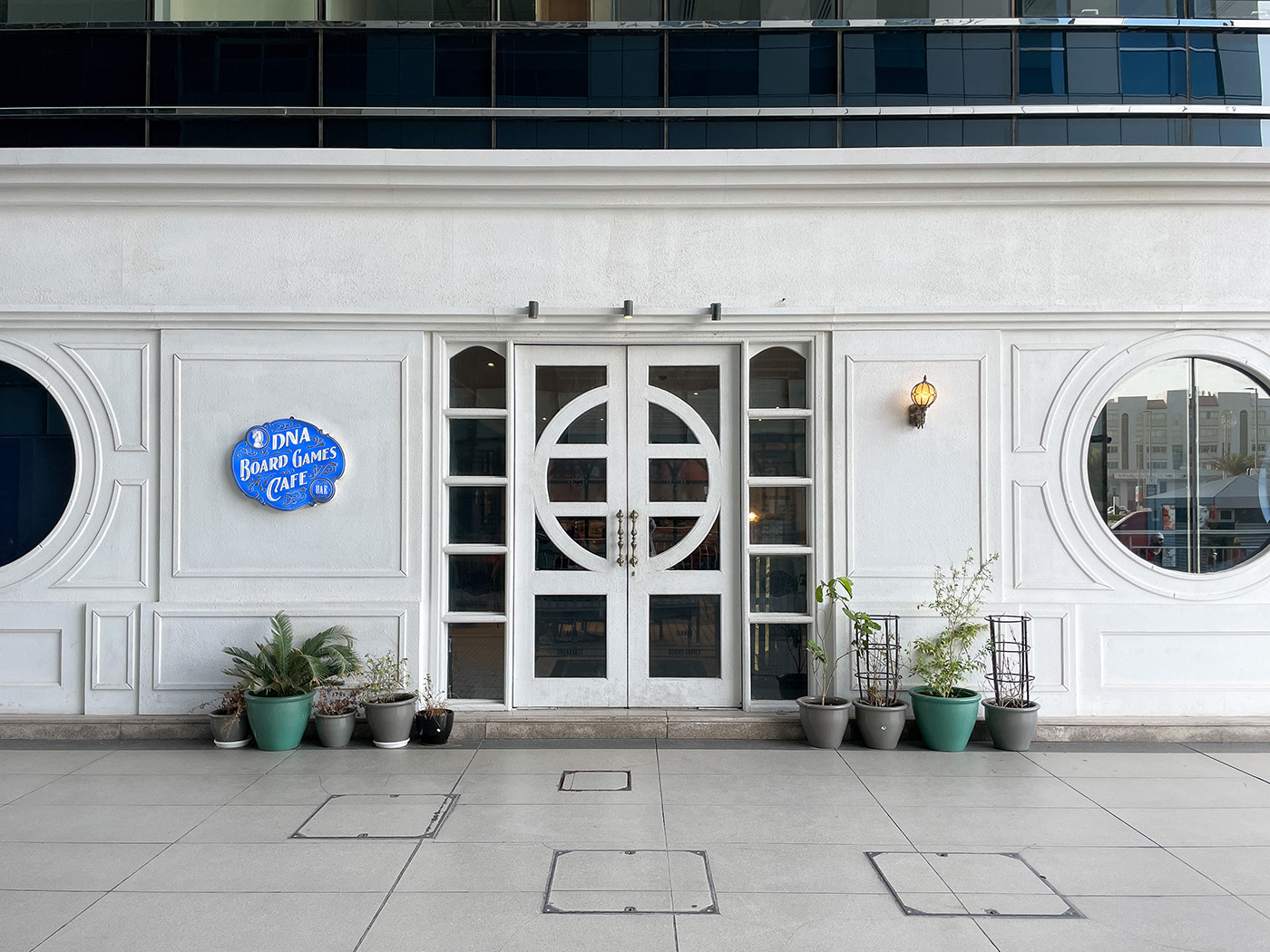 The distinctive round windows and front entrance of DNA Board Games Cafe in Montazah Tower